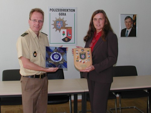 Austausch von Polizeiplaketten zwischen Polizeioberrat Thomas Quittenbaum und Deputy Chief Nancy Becher